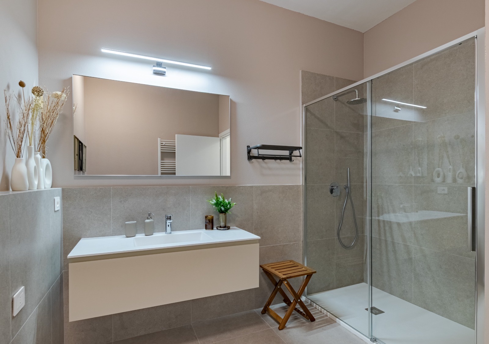 Bathroom with a floating vanity, backlit mirror and glass walk-in shower