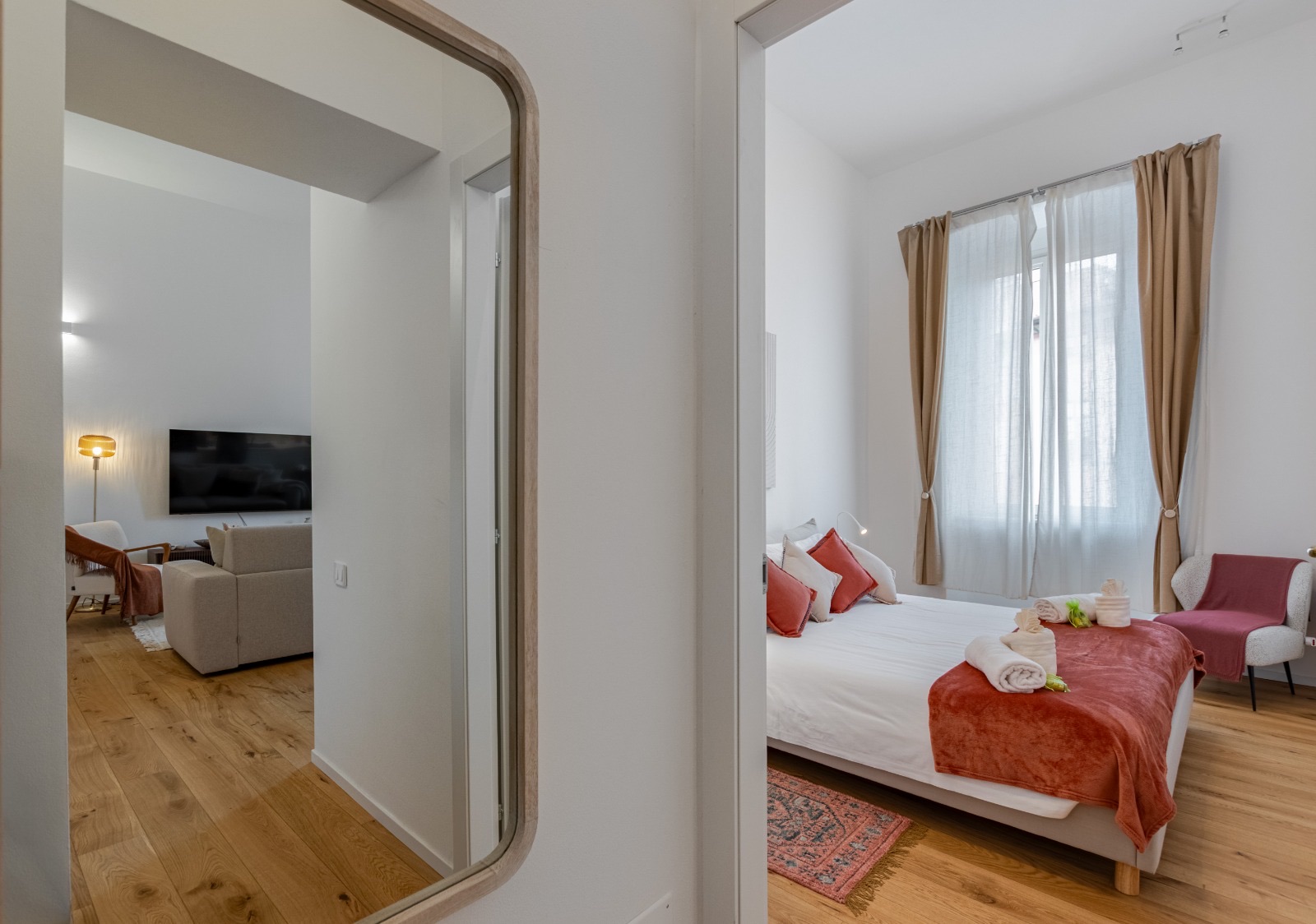 Bedroom with a double bed, terracotta cushions and throw, and long curtains